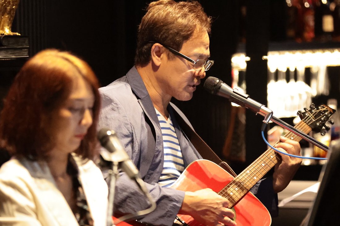 นักดนตรีเล่นกีตาร์และร้องสดที่ Owl's Nest Bar & Bistro ปากเกร็ด